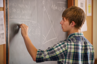 Student demonstrates a proposition on the chalkboard 